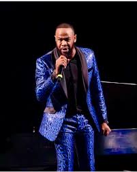 DeWayne Woods performing on stage in blue jacket